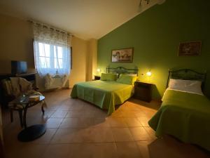 a green bedroom with two beds and a window at Agriturismo Francemili in Cerreto Sannita
