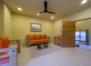 a living room with orange furniture and a ceiling fan at !Vive como local, 3 departamentos juntos, piscina y céntrico! in Valladolid