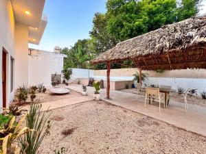 a patio with a table and a thatch roof at !Vive como local, 3 departamentos juntos, piscina y céntrico! in Valladolid