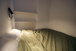 an unmade bed in a corner of a bedroom at Le clocher du château in Fontainebleau