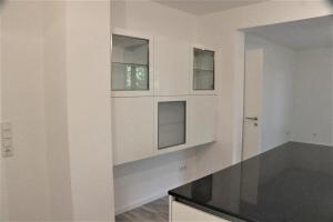 a kitchen with white walls and two windows at Riverside: Messe-, Business-, Ferienwohnung in Leichlingen