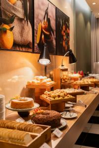 a buffet line with different types of cakes and pastries at Suntory Hotel in Pará de Minas