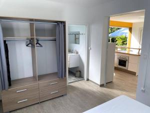 a bedroom with a large wooden dresser and a bathroom at Tiny house paisible en campagne in Petit-Bourg