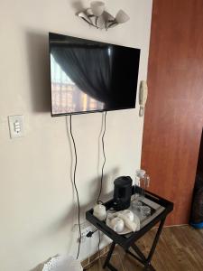 a flat screen tv hanging on a wall with a table at Golden Glory Manor in Roodepoort