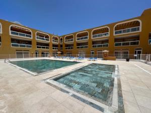a large building with a swimming pool in front of a building at Turquesa Cotillo in Cotillo