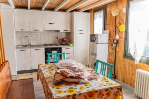 a kitchen with a table and a kitchen with white cabinets at Woodhouse paesana in Paesana