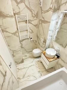 baño de mármol con aseo y lavamanos en AMB Luxury Residence Pipera, en Voluntari