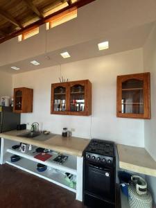 a kitchen with a stove and a counter top at Cabana Alegria - Ocean View Home - 2 Master Suites in San Agustinillo