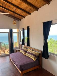 a bedroom with a bed with a view of the ocean at Cabana Alegria - Ocean View Home - 2 Master Suites in San Agustinillo