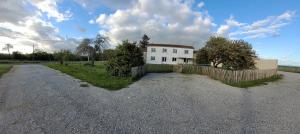 una casa blanca con una valla y un camino de grava en Un séjour à la campagne, en Courpignac