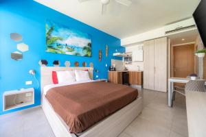 a bedroom with a bed and a blue wall at Tu Oasis en Playa del Carmen in Playa del Carmen +24 photos