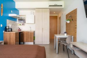 a kitchen and living room with a table and chairs at Tu Oasis en Playa del Carmen in Playa del Carmen