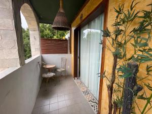 a porch with two chairs and a table on a building at Pousada Sol Da Pipa in Pipa