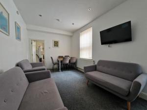 a living room with couches and a flat screen tv at Town centre, very convenient in Newcastle under Lyme