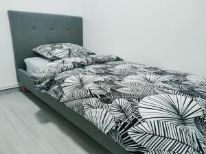 a bed with a black and white comforter and pillows at La Suite Élégance in Obernai
