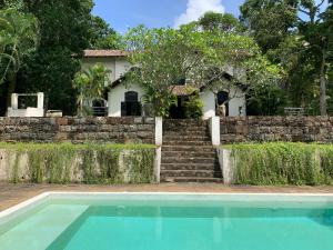 a house with a stone wall and a swimming pool at Galle Henna Estate in Unawatuna