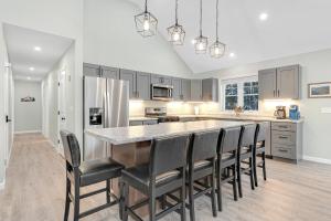a kitchen with a large island with black chairs at Unwind at Our Beautiful Sanctuary - Scenic Views home in Bridgton