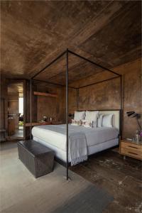 a bedroom with a large bed with a metal canopy at Bruma Wine Resort in Valle de Guadalupe