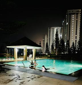 eine Gruppe von Personen in einem Schwimmbad in der Nacht in der Unterkunft Aiya's Cozy Staycation in Tagaytay SMDC Wind in Tagaytay