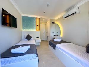 a room with two beds and a bathroom at Akpınar Marin Hotel in Çeşme