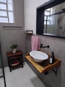 a bathroom with a bowl sink and a mirror at Casa espaçosa pertinho da praia in Santos
