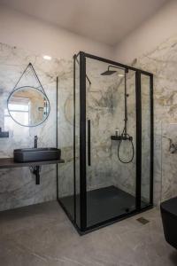 ein Badezimmer mit Glasdusche und Waschbecken in der Unterkunft Evie's Oasis in Ixia