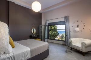 ein Schlafzimmer mit einem Bett, einem Fenster und einem Stuhl in der Unterkunft Evie's Oasis in Ixia