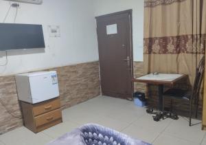 a room with a desk and a television and a table at Amman Palace Hotel in Amman