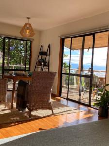 a living room with a table and chairs and sliding glass doors at Fern Cottage Escape in Nelson