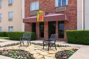 2 sedie sedute di fronte a un ristorante di Super 8 by Wyndham Grapevine/DFW Airport Northwest a Grapevine