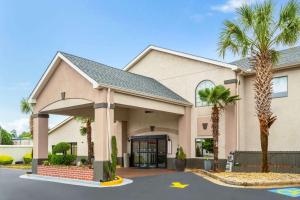 a building with palm trees in front of it at Ramada by Wyndham Locust Grove in Locust Grove