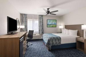 a hotel room with a bed and a flat screen tv at Baymont by Wyndham Mt. Pleasant in Mount Pleasant