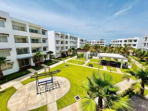 ein Park mit einem Tisch und Palmen und Gebäuden in der Unterkunft cómodo con alberca cerca de la playa by G P S rentas in Mazatlán