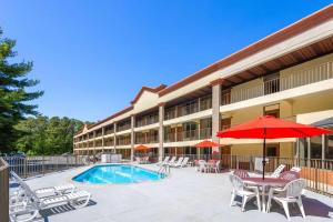 un hotel con piscina, sedie, tavolo e ombrellone di Inn at Atlantic City Hotel & Banquet ad Absecon