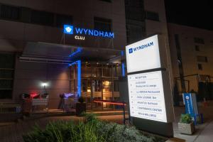 una señal frente a un edificio por la noche en Wyndham Cluj, en Cluj-Napoca