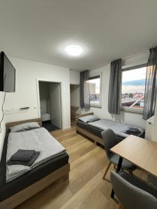 a room with two beds and a table and chairs at AG Zimmervermietung Fellbach in Fellbach