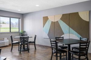 a dining room with two tables and chairs and a painting at Super 8 by Wyndham Humboldt in Humboldt