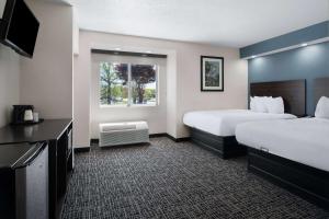 a hotel room with two beds and a television at Baymont by Wyndham Boardman in Boardman +28 photos