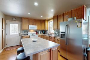 a kitchen with wooden cabinets and a stainless steel refrigerator at The Forest Cottage in Payson