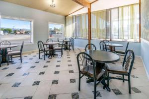 a restaurant with tables and chairs and windows at Days Inn by Wyndham Delta CO in Delta