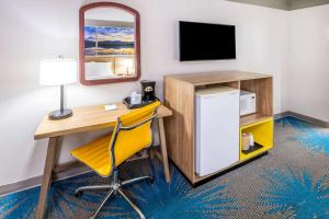 a room with a desk and a refrigerator and a mirror at Days Inn by Wyndham Delta CO in Delta