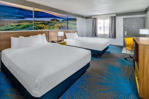 a hotel room with two beds and a desk at Days Inn by Wyndham Delta CO in Delta +58 photos