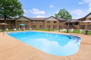 a large swimming pool with chairs and a building at Baymont Inn and Suites by Wyndham Farmington, MO in Farmington