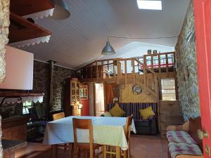 a dining room with a table and a staircase at Moinho do Formigal in Valença