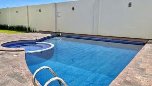 a swimming pool with blue water in front of a building at Hotel Renzzo in Río Verde
