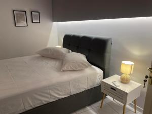 a bedroom with a bed and a nightstand with a lamp at Alyzia Apartment in Xylokastro