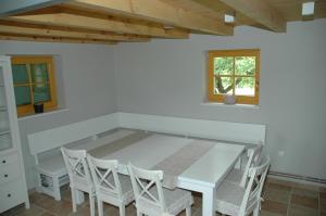 uma sala de jantar com uma mesa branca e cadeiras em Country house Martinova Klet em Prosenjakovci