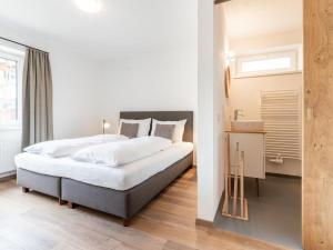 a bedroom with a large bed and a sink at Heimelig L in Saalbach-Hinterglemm