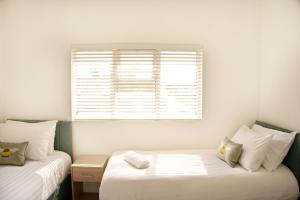 een kleine kamer met twee bedden en een raam bij Parkgate Central, Station & Town in Darlington