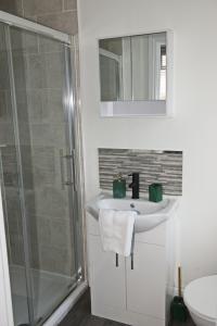 een badkamer met een wastafel, een douche en een spiegel bij Parkgate Central, Station & Town in Darlington